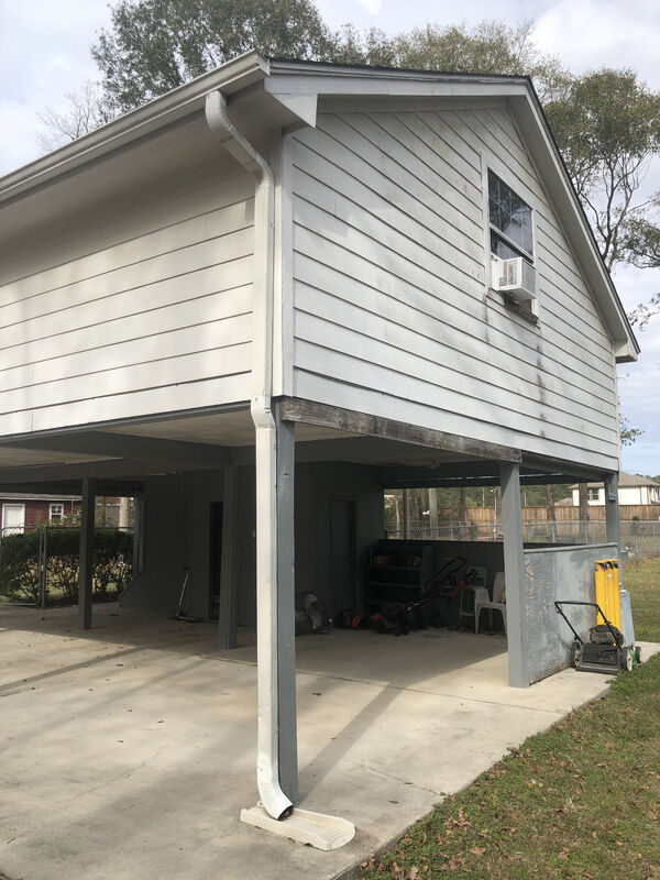 Corner view of the open carport and steel support posts before work began
