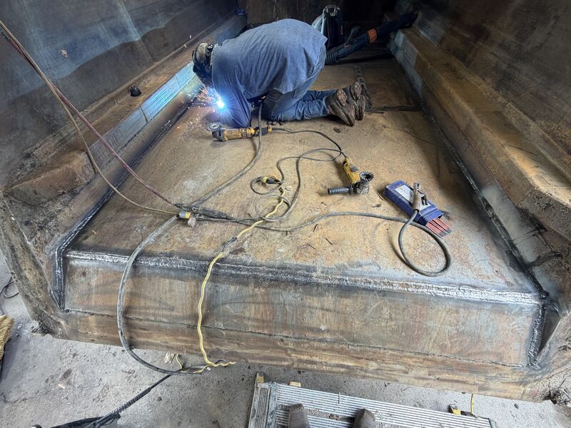 Welding a seam along the floor inside a steel dump bed