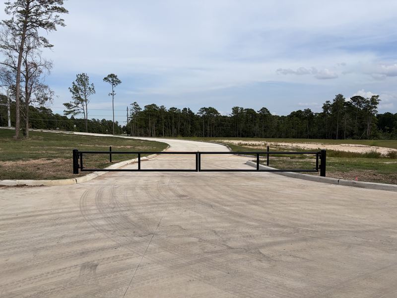 Long steel barrier gate across a park access drive
