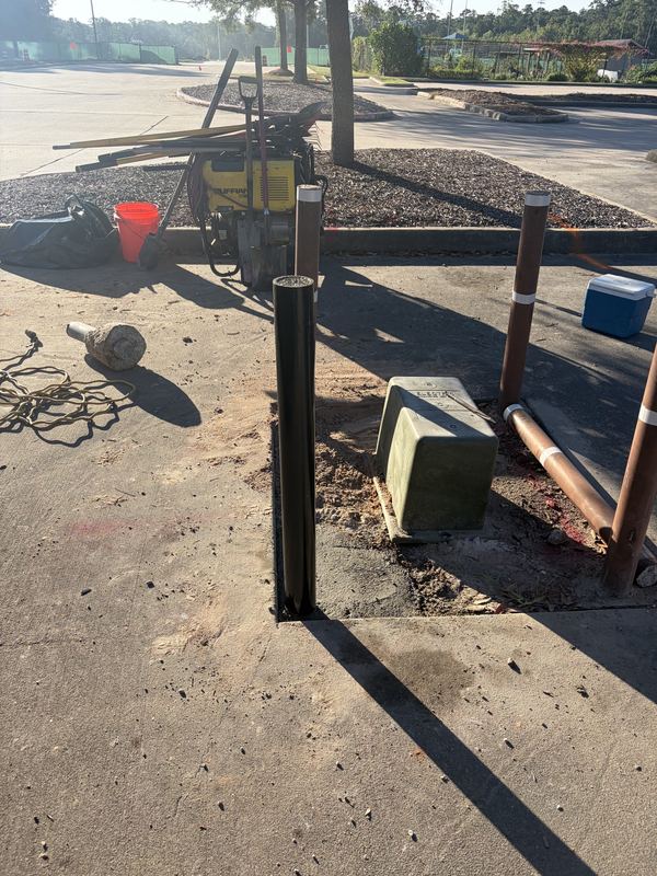 New steel gate post set in fresh concrete during installation
