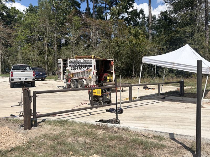 Barrier gate fabrication in progress with welding equipment and canopy on-site