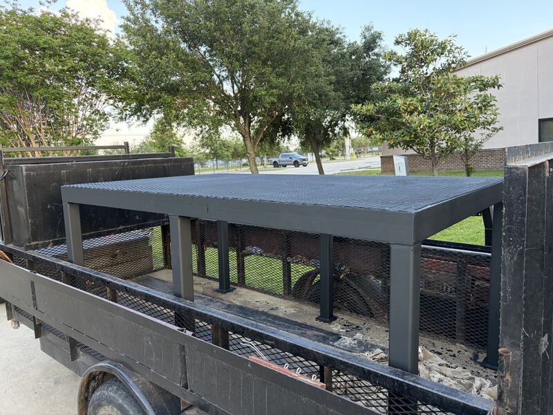 Fabricated steel platform rack with a grated deck loaded on a trailer